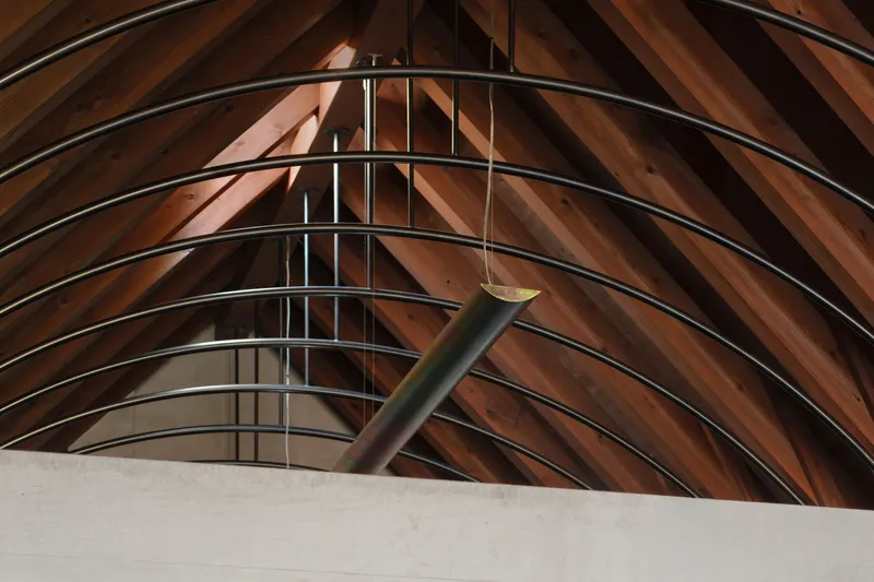 Steel railings along concrete edge with timber pendant light beneath exposed wood ribs