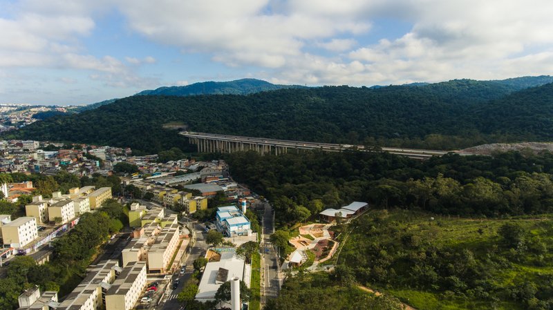 Drone view showing the site bordered by residential buildings and a distant elevated highway viaduct