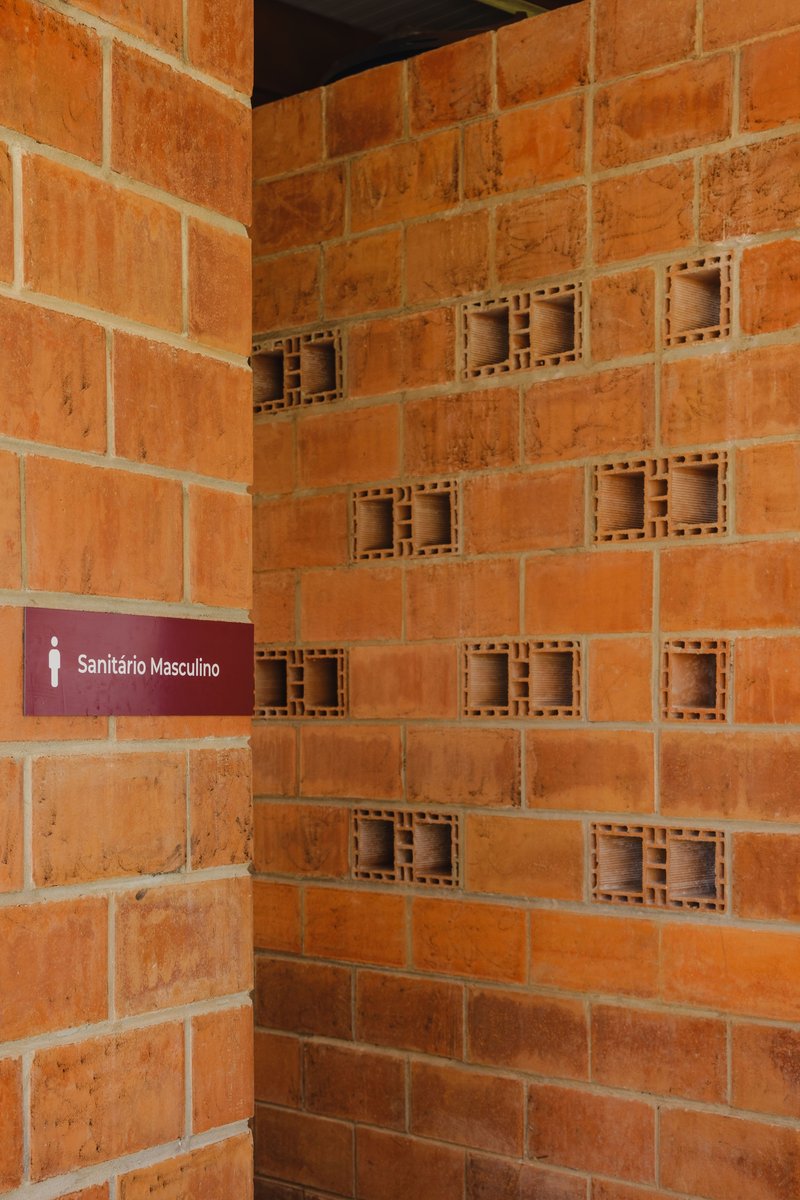 Corner detail of red terracotta block wall with hollow units and wayfinding signage