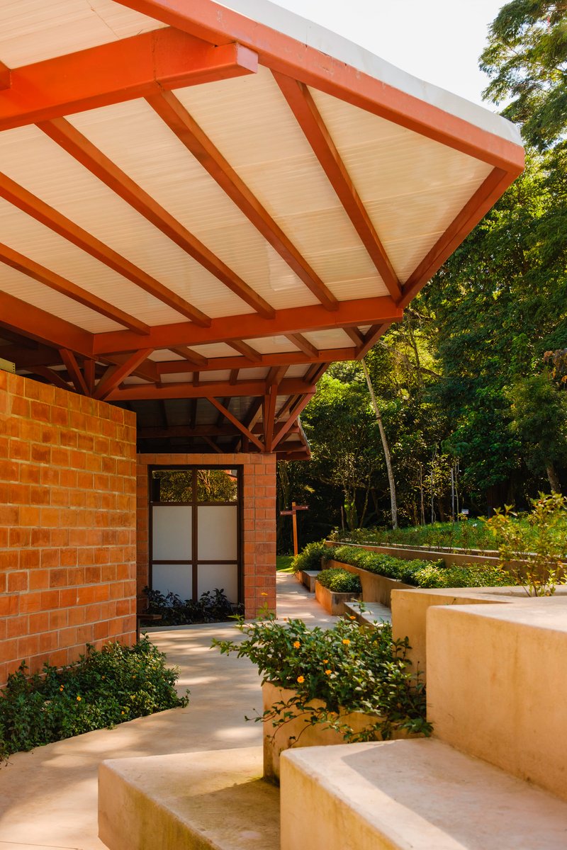 Underside view of timber roof structure with slatted ceiling panels over brick entrance and steps