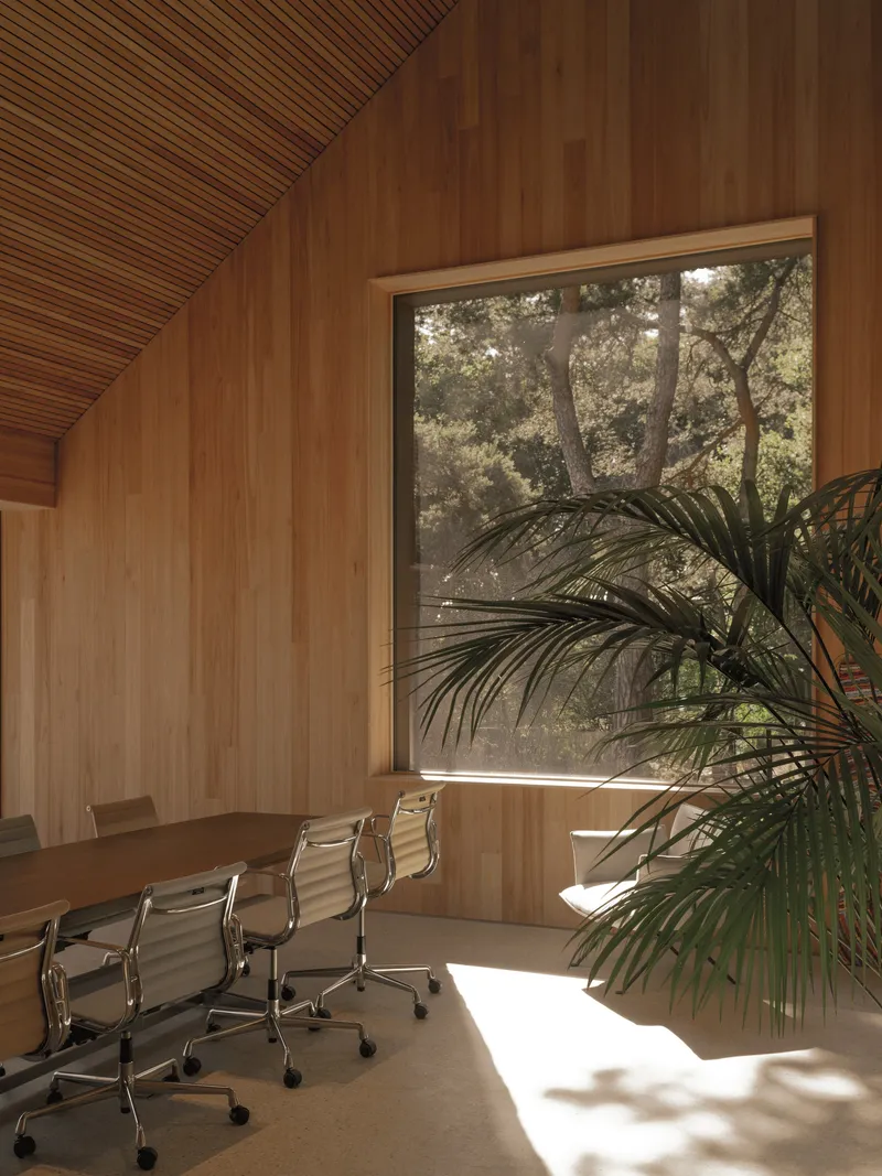 Conference room with timber walls and angled slatted ceiling framing a window view of trees