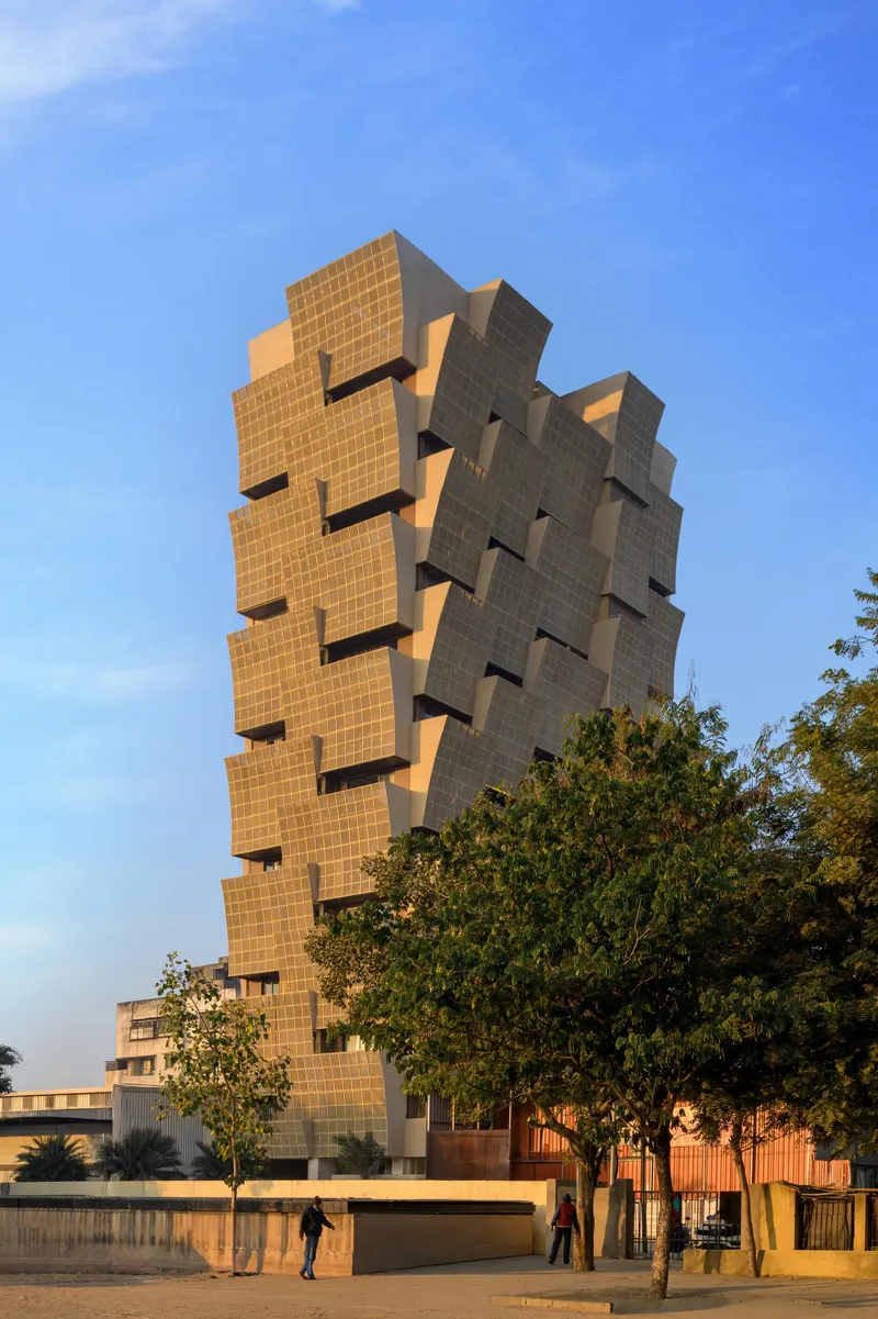 Street view of the offset brick facade with pedestrians walking along the perimeter wall