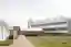 This architectural image showcases a modern industrial building with a distinctive sawtooth roof and
