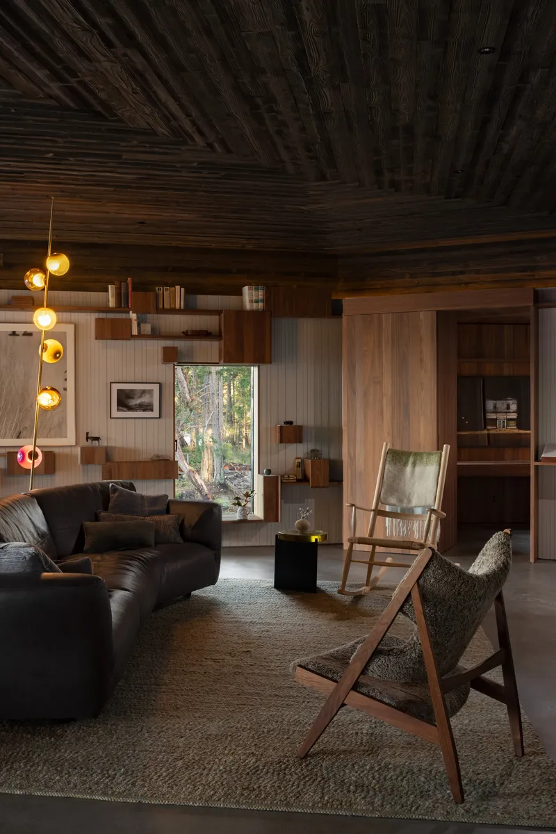 Interior with charred wood ceiling and suspended globe pendants above upholstered seating