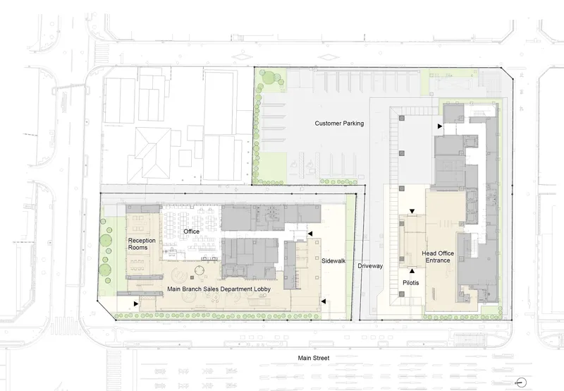 Site plan drawing showing two building volumes with parking lot and surrounding street context
