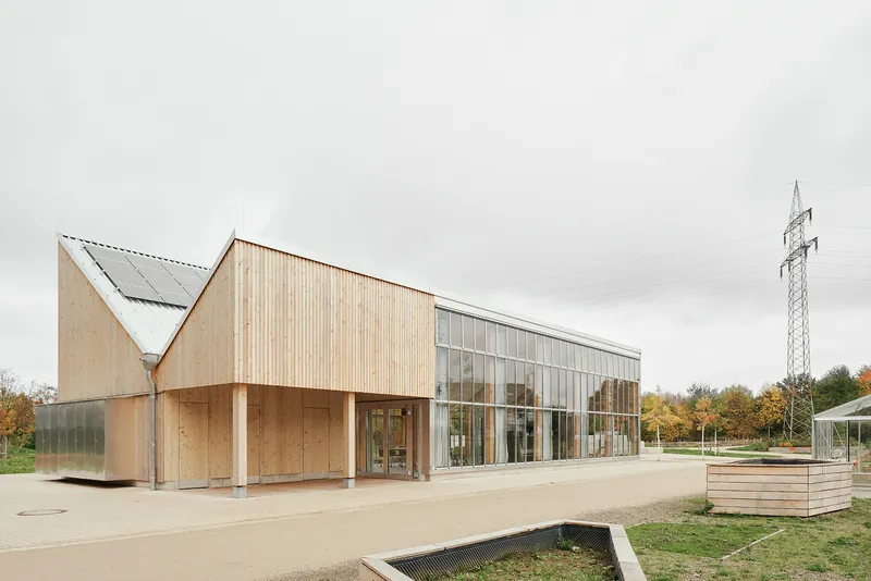 Three-quarter view of the pavilion with raised planting beds in the foreground