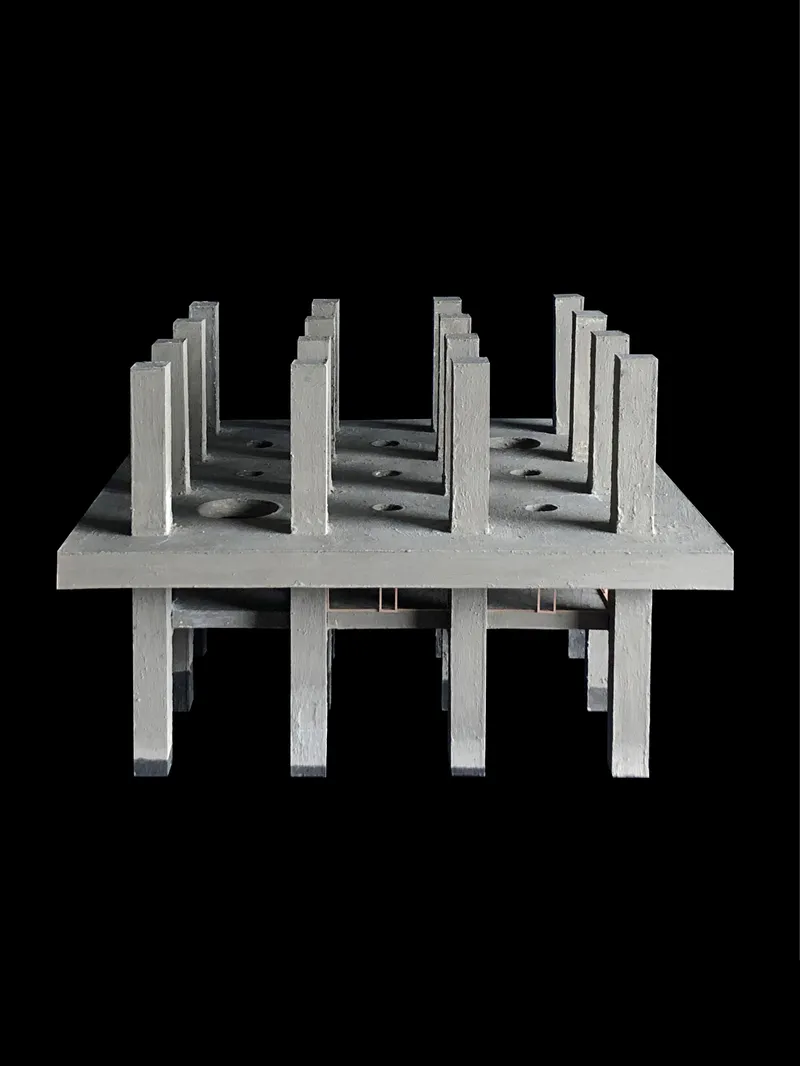 Physical model showing rows of vertical fins casting shadows across the elevated platform