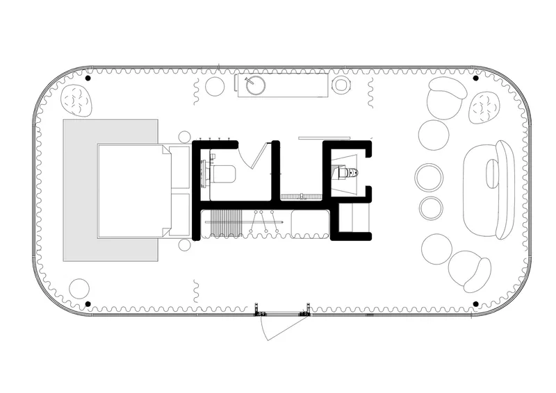 Floor plan drawing showing oval footprint with central bathroom and bedroom flanked by curved perimeter deck