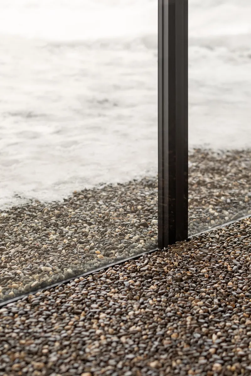 Detail of glazing profile meeting polished aggregate terrazzo floor with exposed stone