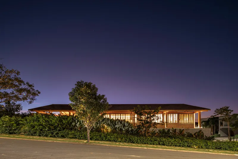 Street view of the illuminated glazed facade and low-pitched roof at night