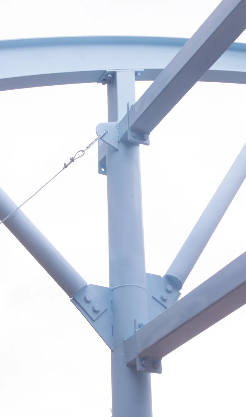 Detail of painted steel tubular column with bolted plates and a tensioned cable connection