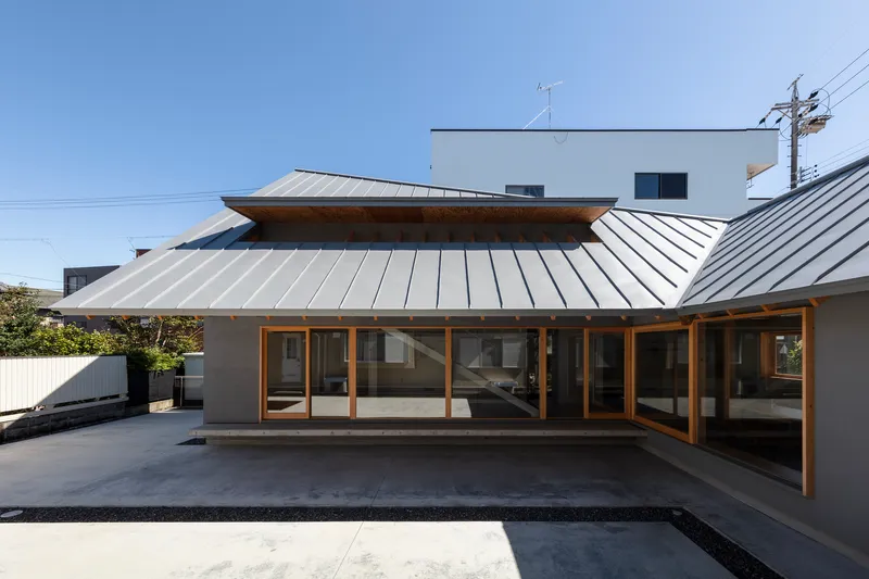 Courtyard view of the standing seam metal roof canopy with timber framing over full-height glazed doors
