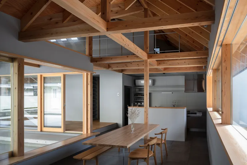 Dining area with exposed timber post-and-beam structure and skylights illuminating the wood ceiling