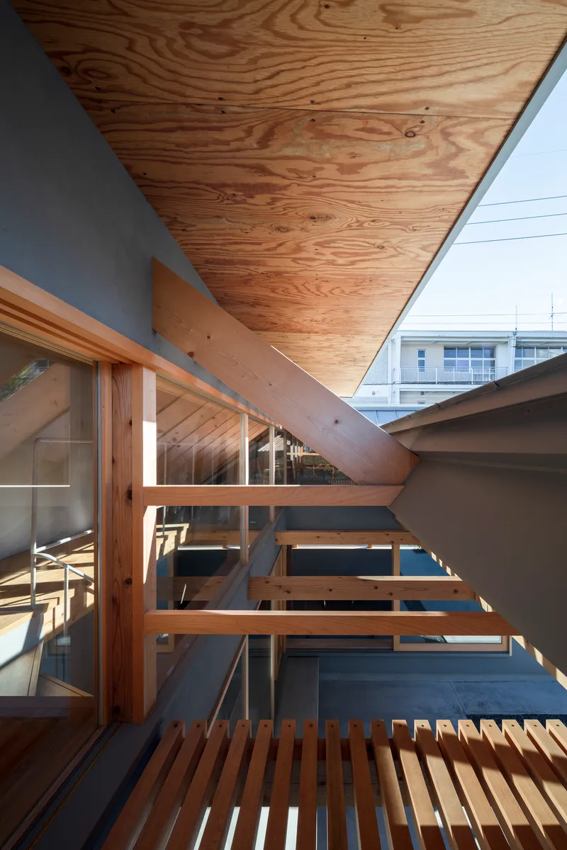 Exterior timber deck with slatted walkway and plywood soffit under bright blue sky