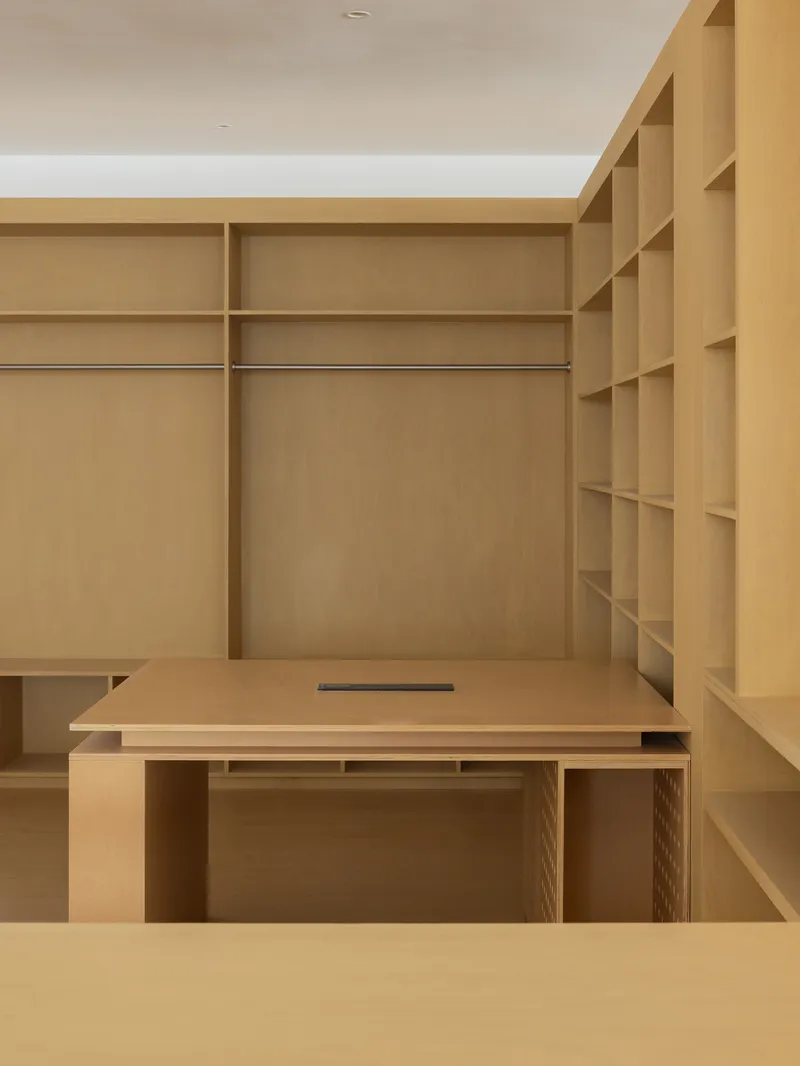 Built-in birch plywood desk and shelving system with hanging rails and recessed finger pull
