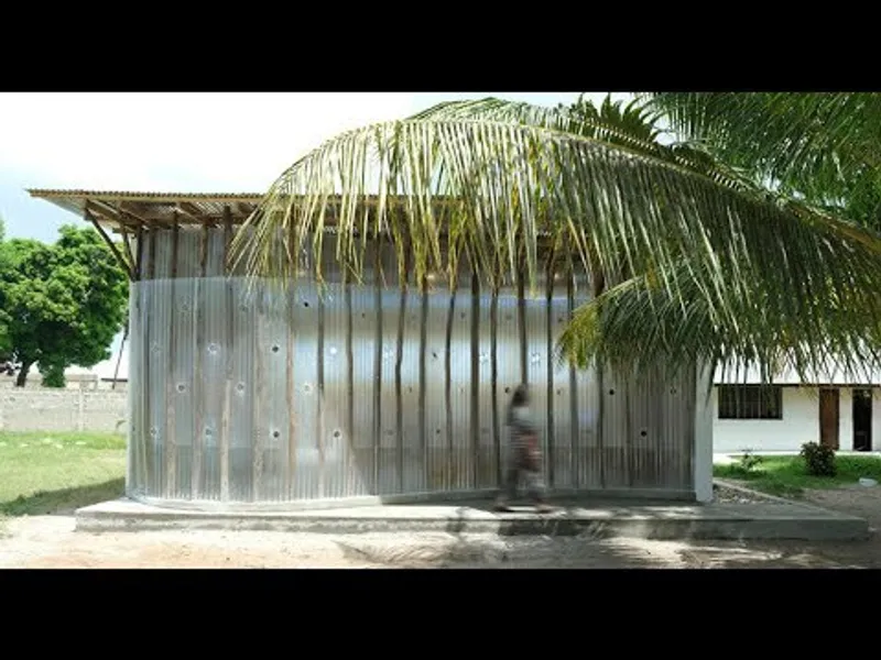 Corrugated metal facade with thatched palm roof shading the entrance on a sunny day