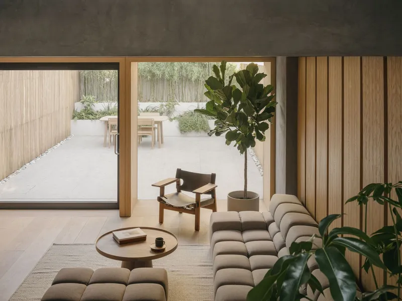 Interior view showing fluted timber wall panels beside sliding doors to the planted courtyard