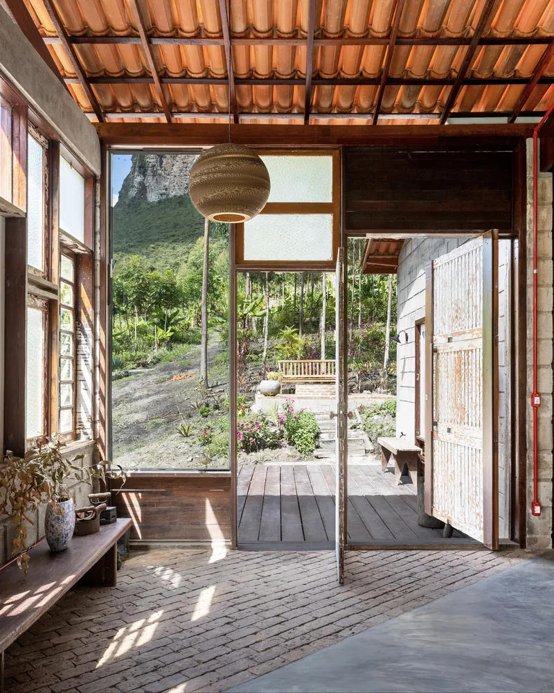 Entry foyer with exposed clay tile ceiling looking out through open doors to garden courtyard and vegetated slope