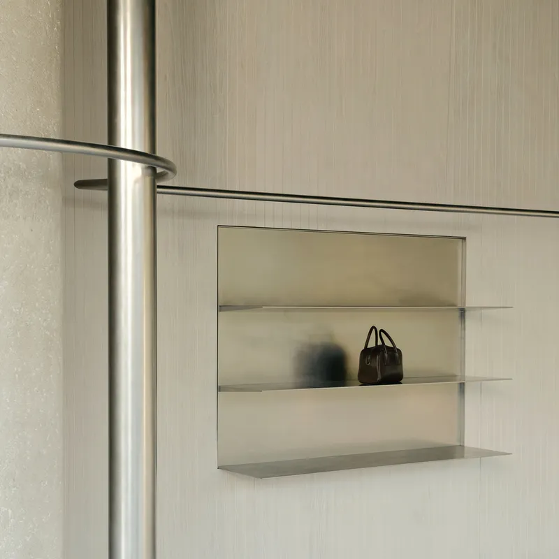 Recessed display niche with glass shelves set into the vertical grooved wall panel