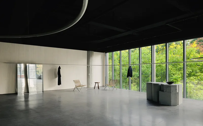 Polished concrete floor reflecting daylight from glazed walls overlooking trees in leaf