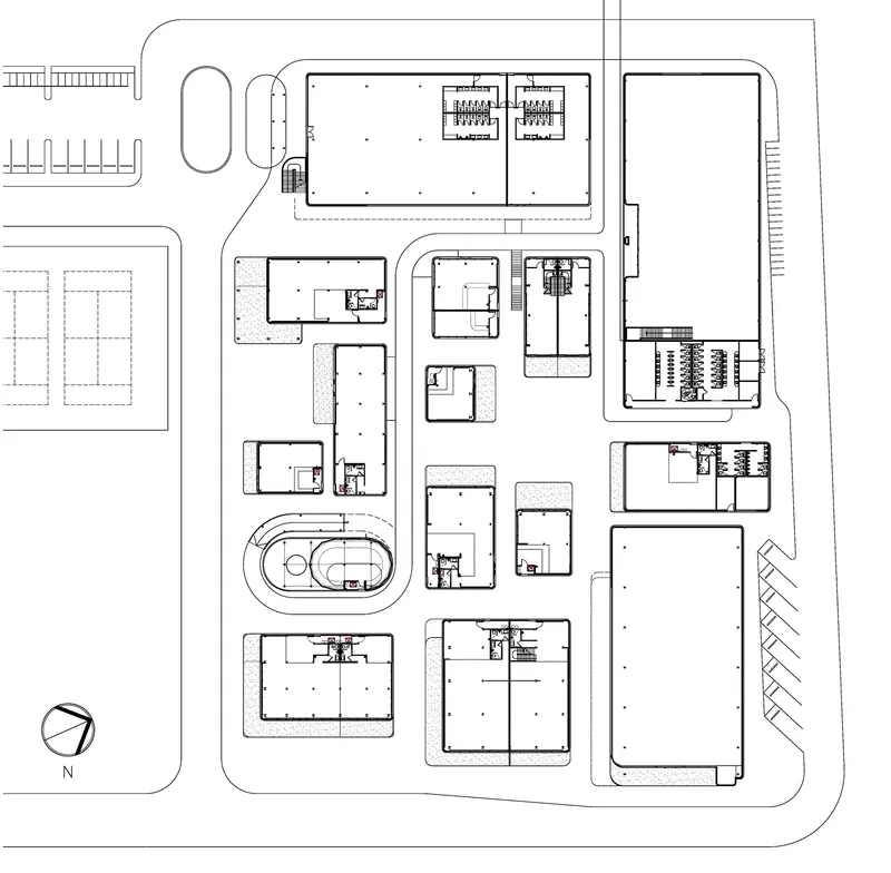 Site plan drawing showing multiple rectangular buildings arranged around a central oval structure
