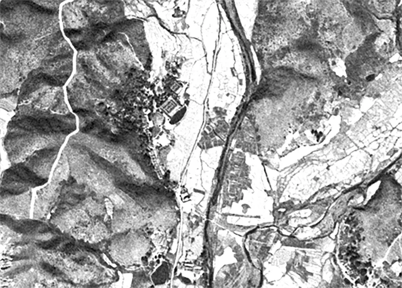 Aerial site plan drawing showing a village settlement along a river valley within mountainous terrain