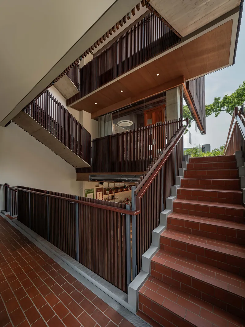 Stairwell with terracotta tile treads, vertical timber slat screens and timber-lined soffit above