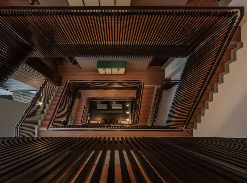 Top-down view of the central stair void with slatted screens and terracotta tile steps