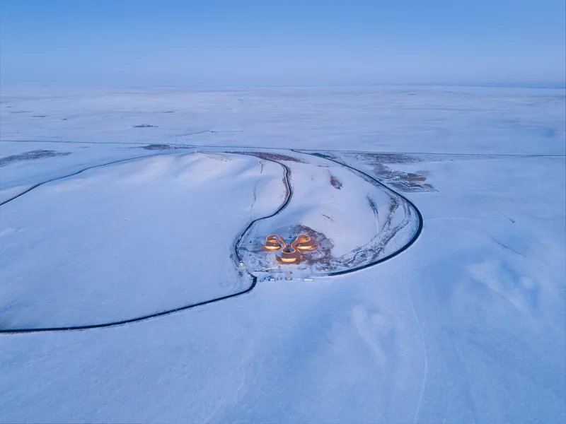 Aerial of the building set inside the C-shaped curve of the extinct volcano at dusk