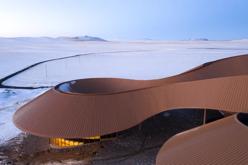 Long view of the fluid roof curves stretching across the white landscape
