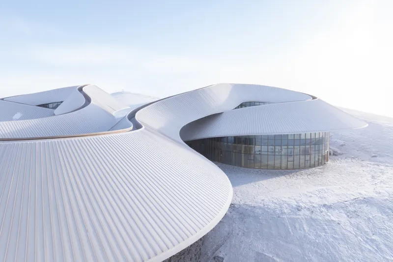 Close-up of the meeting of two roof lobes around a curved glazed drum