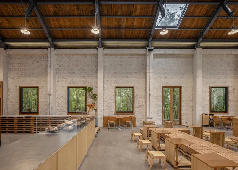 White brick wall with timber-framed windows and polished concrete floor in afternoon light