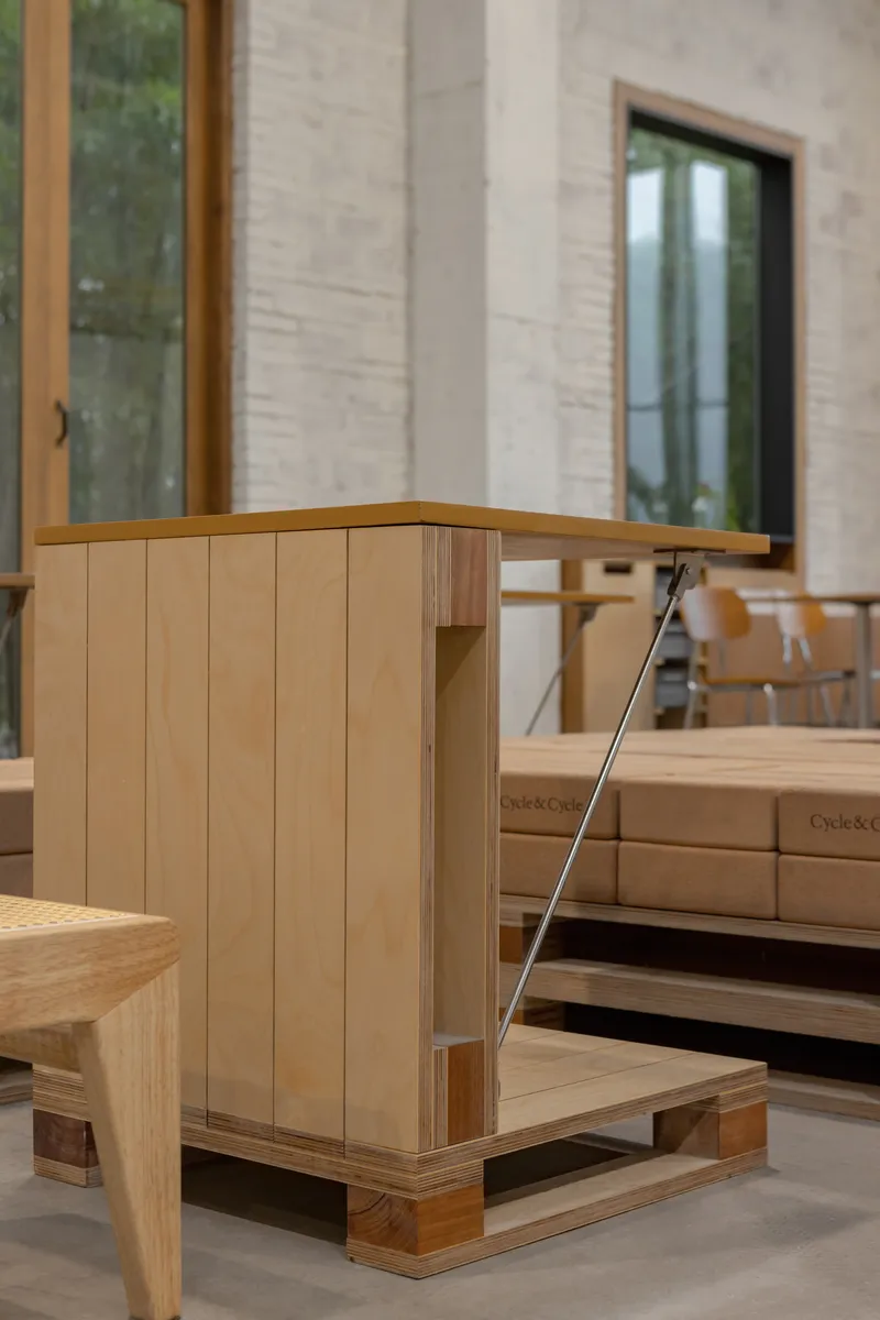 Corner detail of timber display cabinet with vertical slat cladding on polished concrete floor