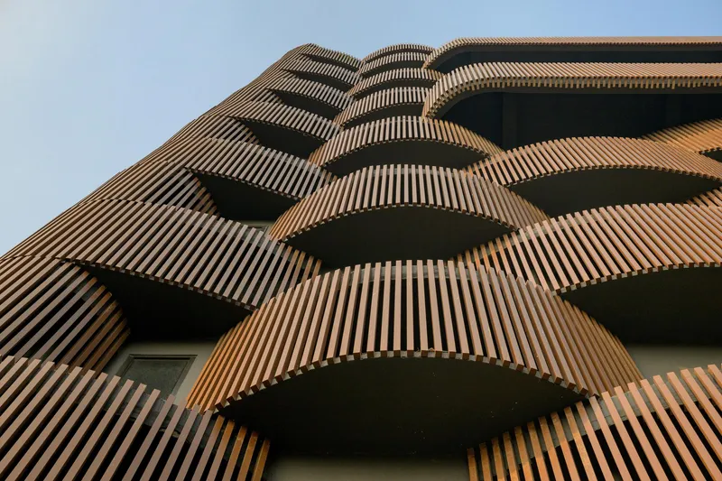 Upward view of the staggered terracotta-clad balconies wrapping the tower volume