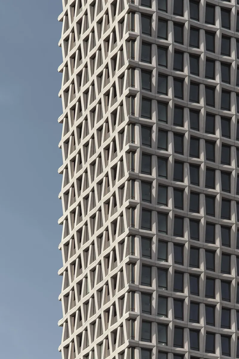 Close-up of the diagonal grid window pattern created by angled concrete mullions