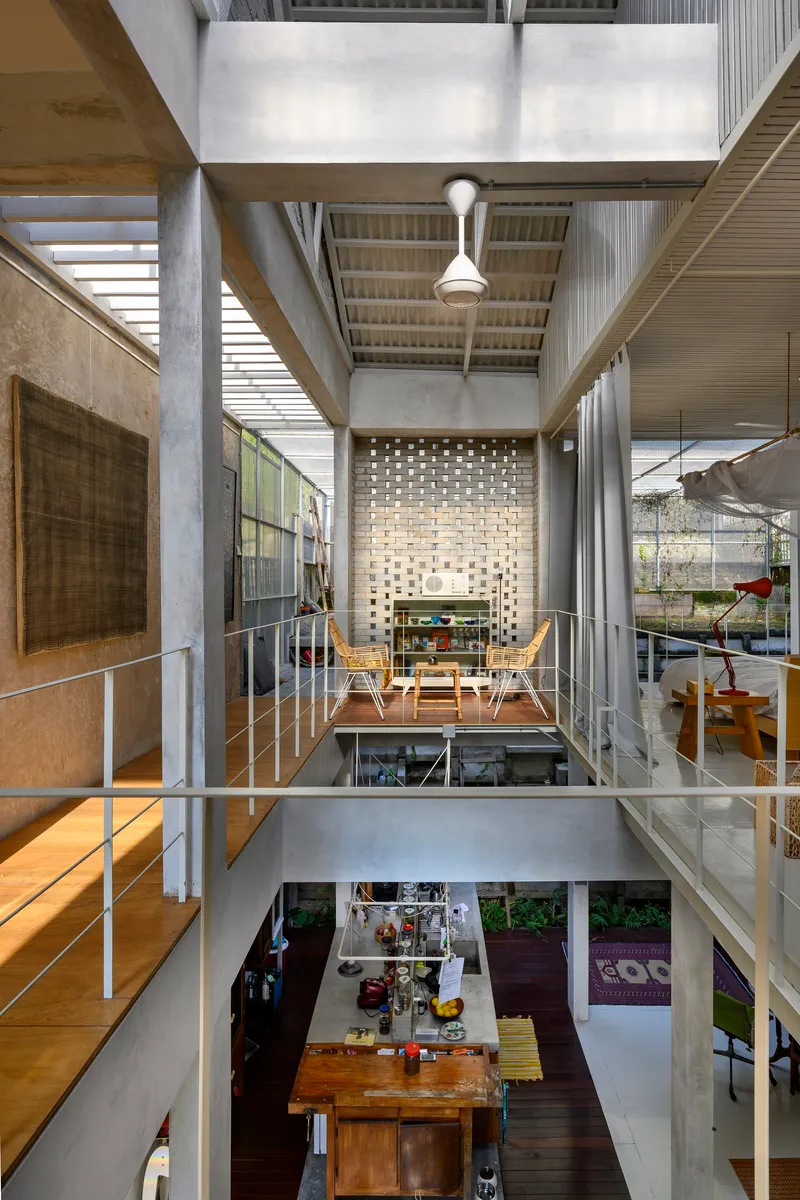 Vertical section through multi-level interior showing perforated brick screen, bridges, and open dining space below