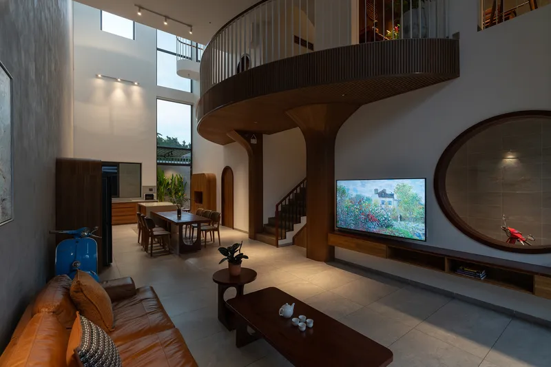 Double-height living area with timber mezzanine supported by curved columns and arched openings below