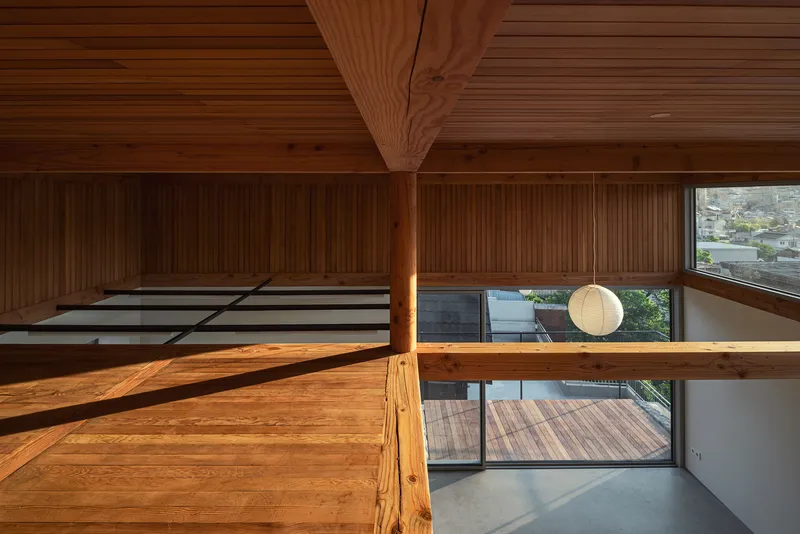 View from mezzanine showing timber post-and-beam construction and horizontal window opening below suspended pendant light