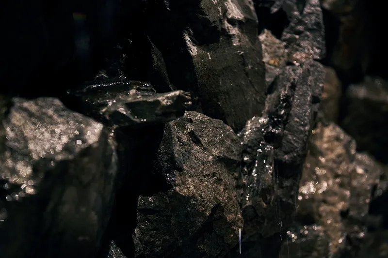 Water droplets running over dark basalt rocks in close-up detail