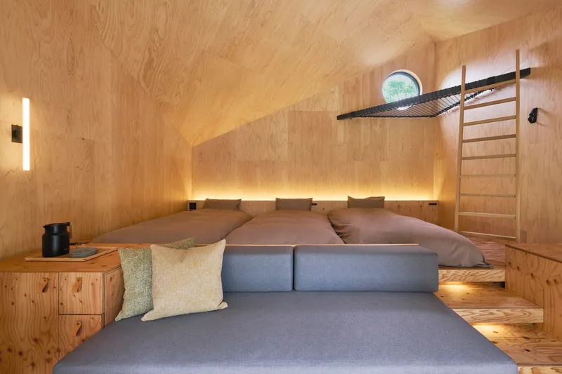 Interior view of gabled sleeping loft with continuous strip lighting beneath the bed platform