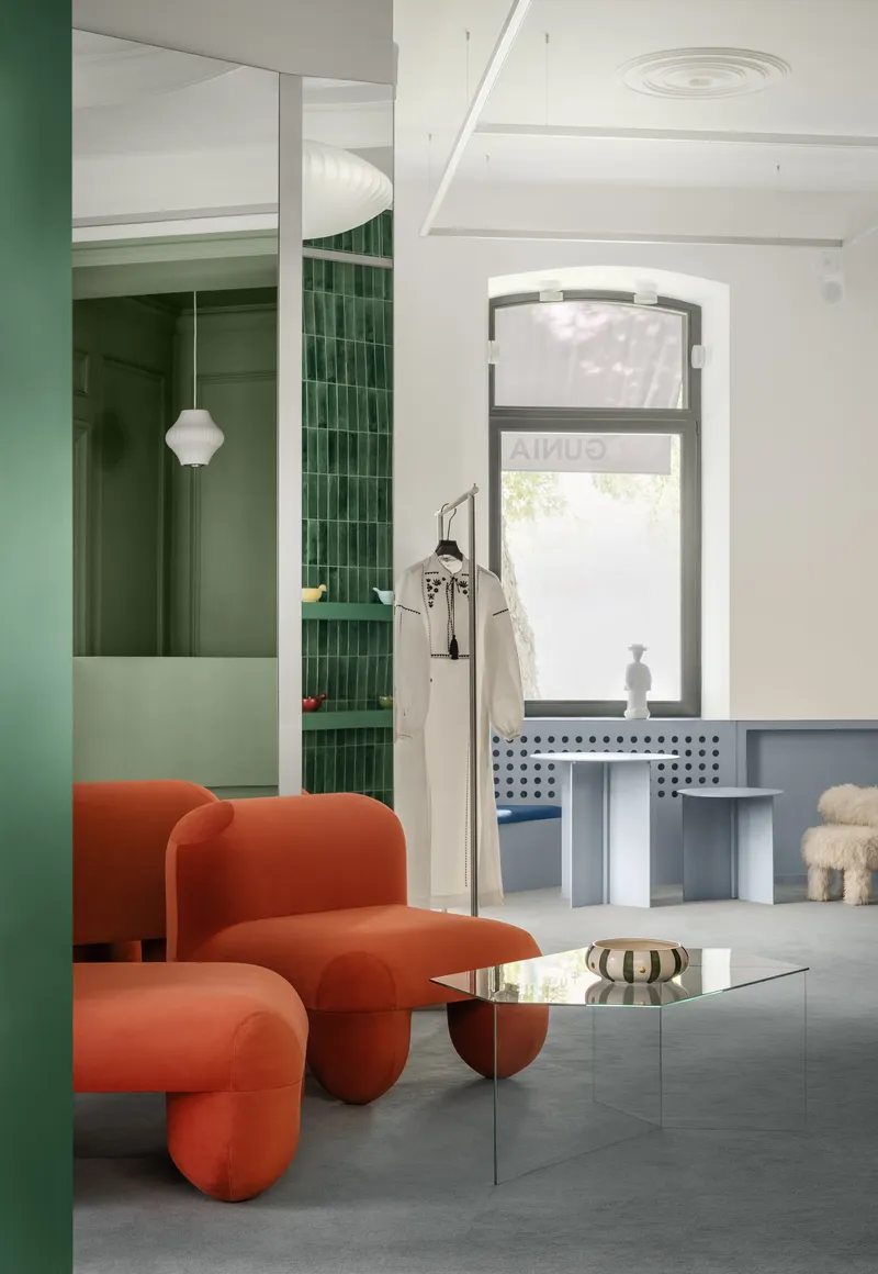 Interior with arched window, green tiled niche, and pendant light casting shadows on polished concrete floor