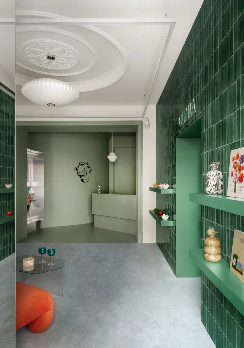 Green tiled wall with floating shelves and ornamental ceiling medallion above pendant fixture