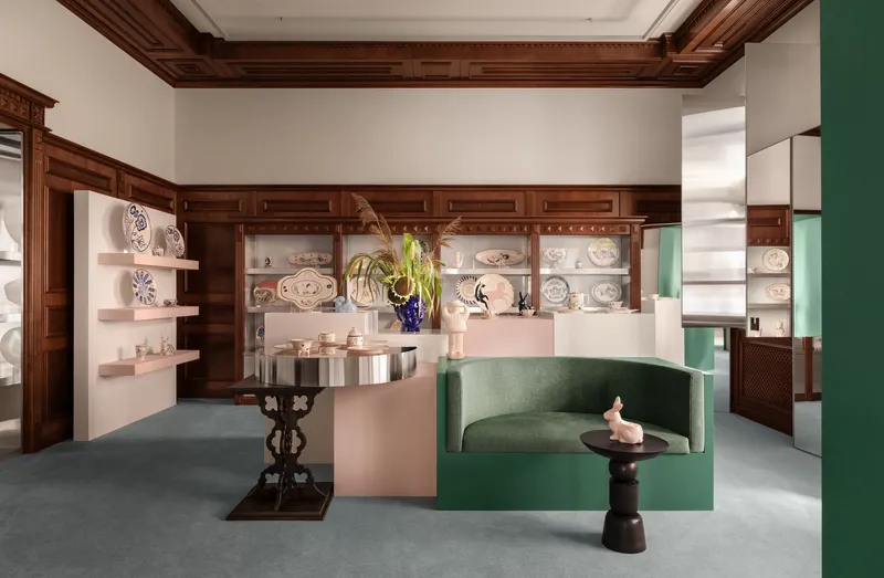 Interior room with dark timber coffered ceiling, built-in shelving and green upholstered seating