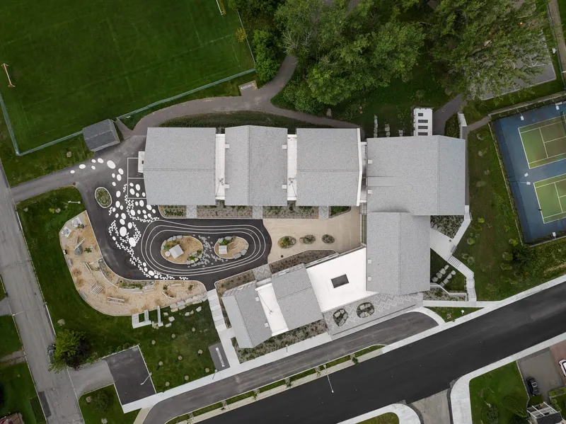 Top-down view of the white rooftops enclosing a central courtyard with oval track and landscaped areas