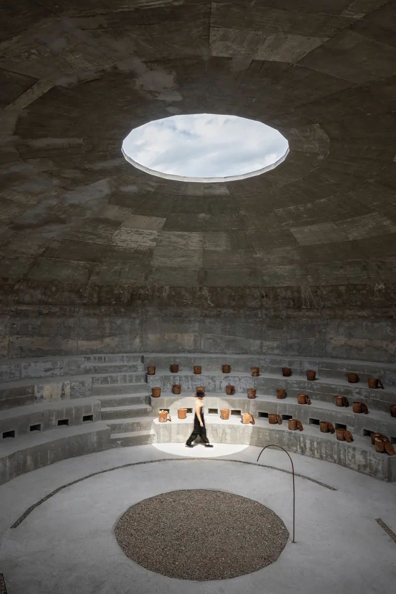 View up to the circular oculus in the dome ceiling with a figure seated on the lower benches