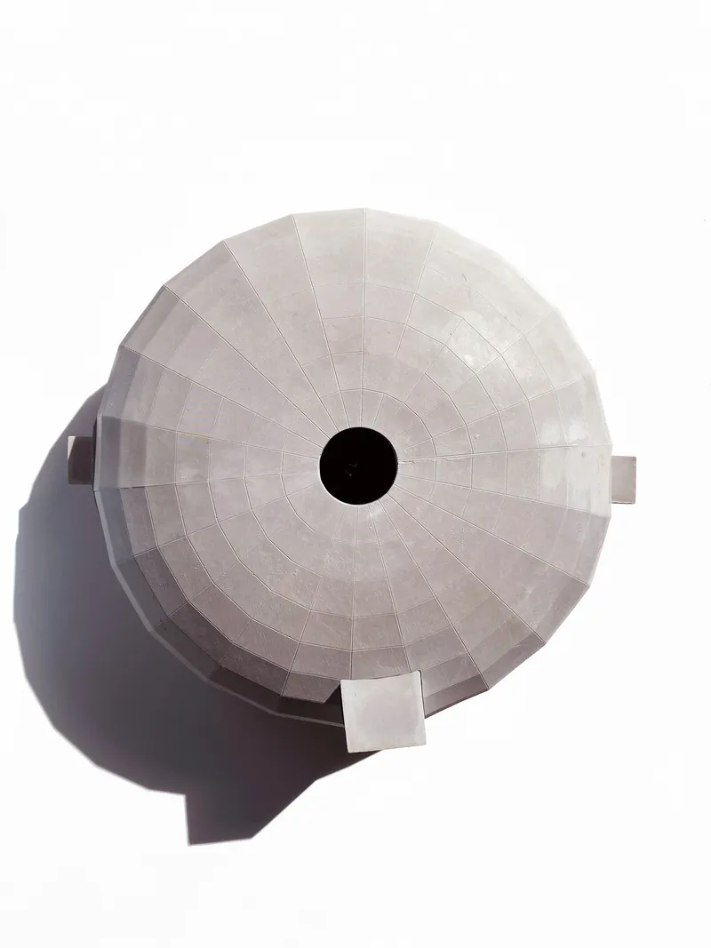 Top-down view of the circular dome roof showing radial concrete panels and central opening