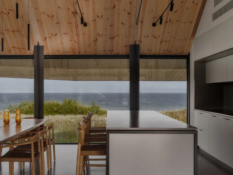 Open dining area with timber ceiling looking out to infinity pool and distant water horizon