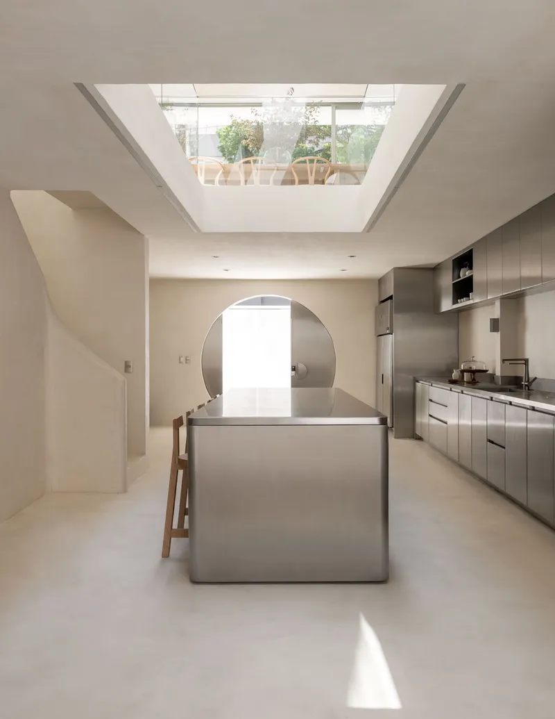 Kitchen island beneath a rectangular skylight framing a view of the rooftop terrace above