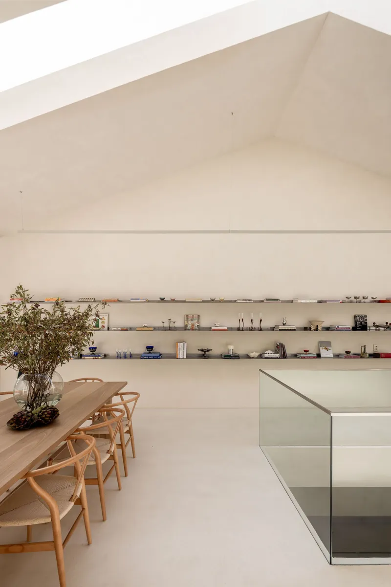 Dining area with timber table and glass balustrade overlooking lower level under pitched ceiling