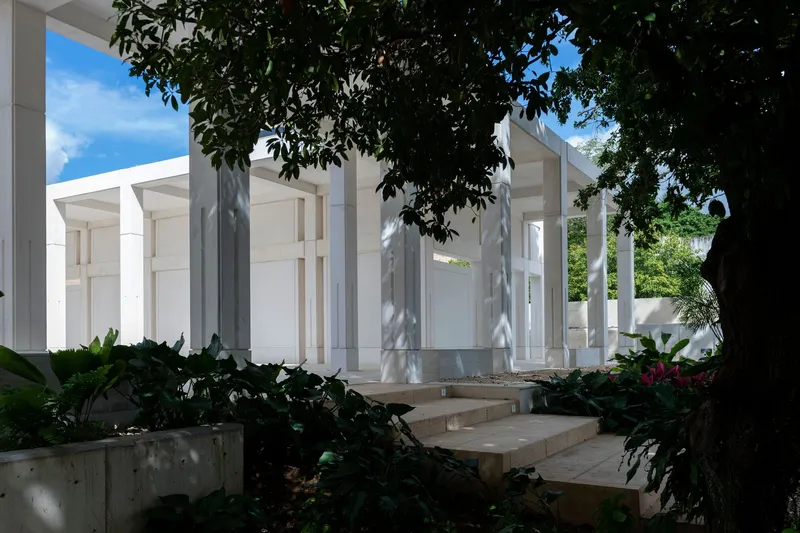 Garden entrance with concrete planters and mature tree canopy shading the stepped pathway